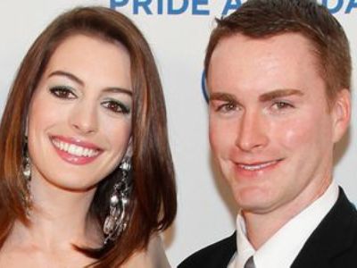 Anne Hathaway is standing next to Michael Hathaway in the picture as they can be seen posing for the camera at an event.